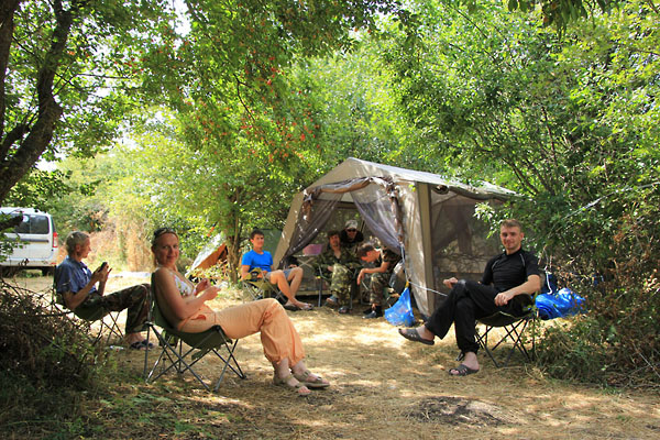 Палатки летнего лагеря специально устанавливаются под кустами, так как это наилучшая защита от солнца, ветра, а иногда и града.