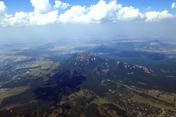 Гора Бештау, если смотреть от Юцы, расположена за Пятигорском и немного левее него. Она примерно на 300 м выше Машука, но из-под крыла параплана эта разница почти не ощущается.
