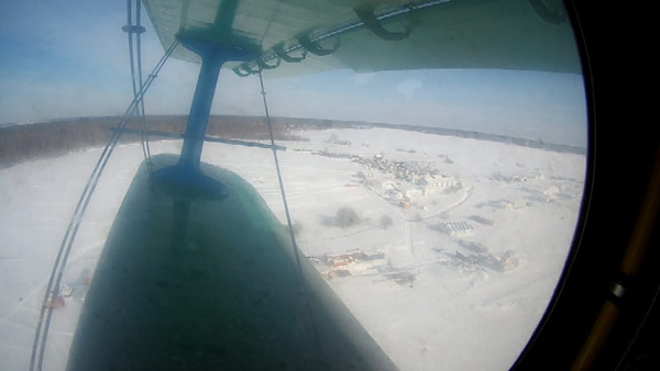 Ан-2 идет на взлет. В иллюминаторе видны самолетная стоянка и авиагородок Ватулино.