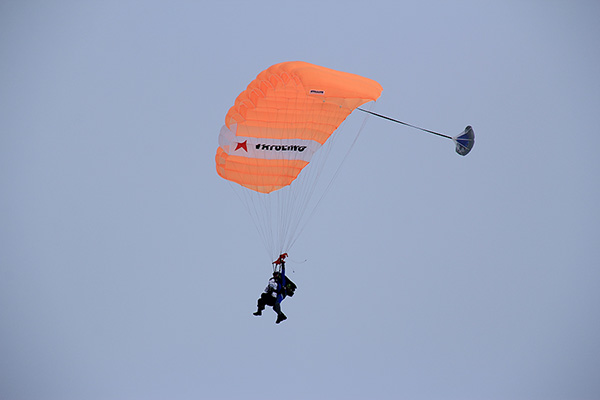 Лена в воздухе под парашютом-тандемом (Лена спереди, инструктор сзади).