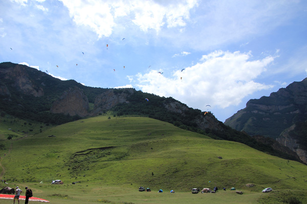Основной парапланерный старт на вершине травяного основания горы Зинки, а над горой уже реет рой больших и маленьких крыльев.